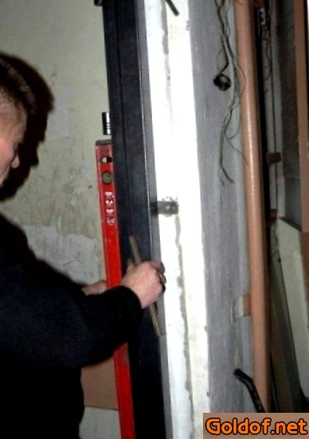 Проверяем вертикаль дверной коробки после засверливания отверстий